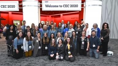 Large group of students posing for photo outside CEC 2020 convention sign